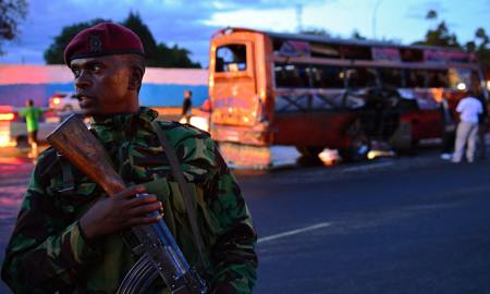 A soldier guards one of the stricken buses on Sunday 