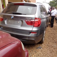 Ugandan police inspect a collection of stolen BMW, Mercedes and Range Rover SUVs